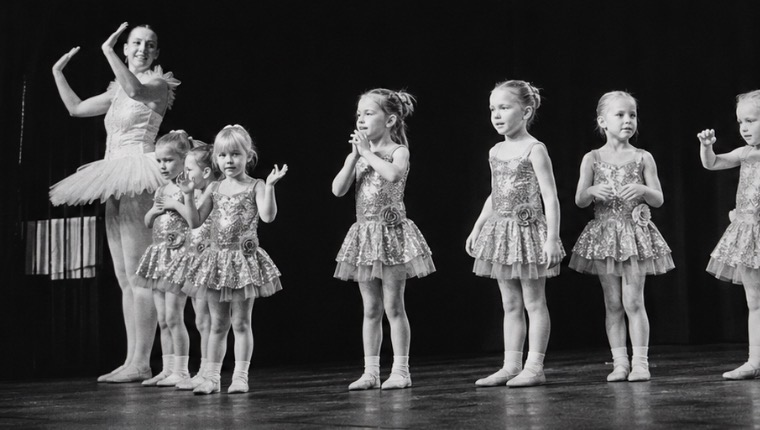 Young dancers performing on stage with their teacher