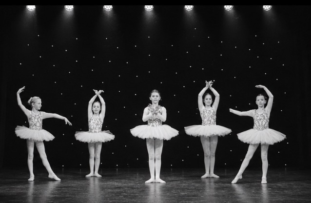 Ballet dancers performing under stage lights